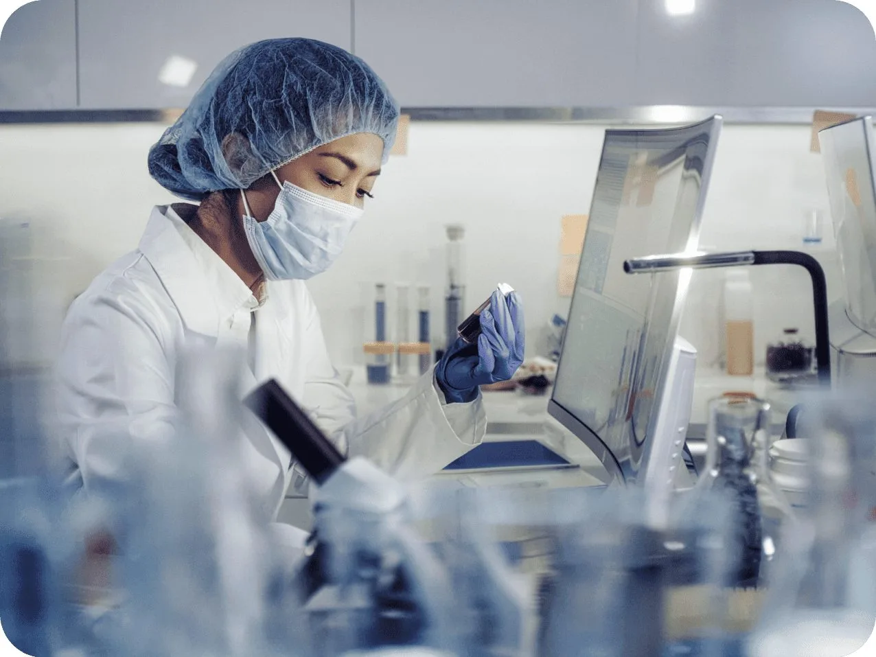 Une technologiste examine un échantillon au microscope